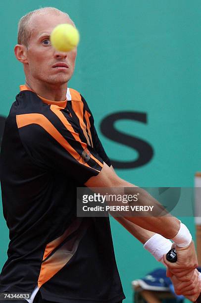 Russian player Nikolay Davydenko eyes the ball as he prepares a backhand shot to Italian player Stefano Galvani during their French Tennis Open first...