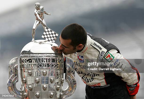 Dario Franchitti, driver of the Canadian Club Andretti Green Racing dallara honda, kisses the Borg-Warner Trophy in celebration of winning the IRL...