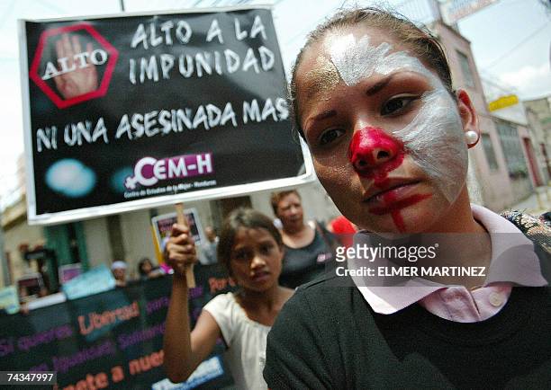 Tegucigalpa, HONDURAS: Una joven pintada de payasa, integrante del Centro de Estudios de la Mujer de Honduras , participa de una protesta en ocasion...