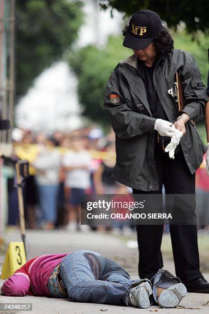 Una investigadora del Ministerio Publico observa el cadaver de una joven asesinada en la Zona 5 de Ciudad de Guatemala, el 28 de mayo de 2007. El...