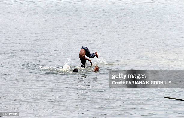 Bangladeshi children bathe in the Turag River to cool themselves during a heatwave on the outskirts of Dhaka, 29 May 2007. City life has been...