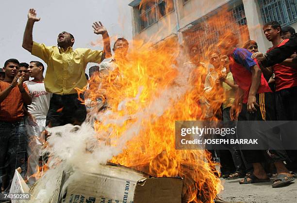 Palestinian refugees, who fled the besieged refugee camp of Nahr al-Bared in north Lebanon, burn boxes of food during a protest in the adjacent...