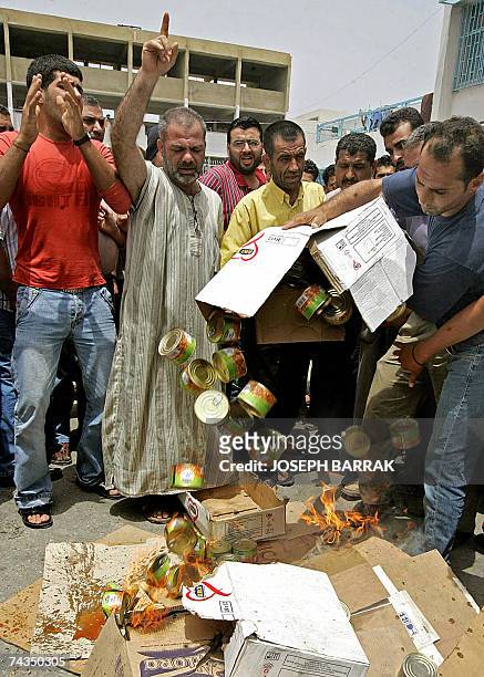 Palestinian refugees, who fled the besieged refugee camp of Nahr al-Bared in north Lebanon, throw canned food during a protest in the adjacent...