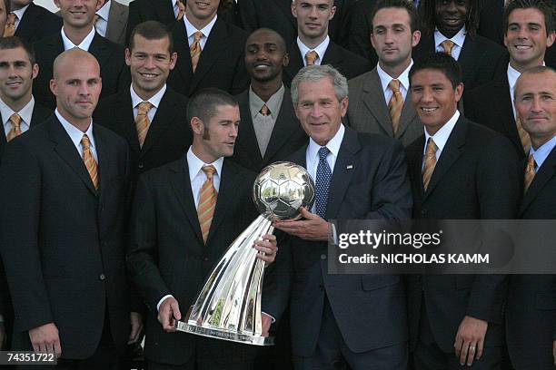 Washington, UNITED STATES: US President Georgwe W. Bush and Houston Dynamo captain Wade Barrett pose with the 2006 Major League Soccer Cup trophy as...