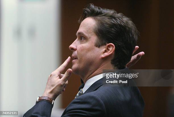 Deputy District Attorney Alan Jackson points to front and back of his head as he questions prosecution witness Dr Louis Pena about the entry and exit...