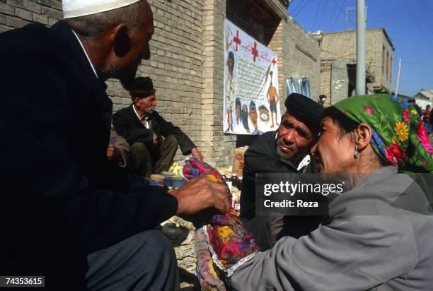 Uighur doctor follows Muslim tradition and uses a handkerchief to avoid direct contact with a female patient July, 1995 in Kashgar, China.