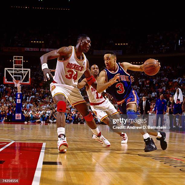 John Starks of the New York Knicks dribbles against Hakeem Olajuwon of the Houston Rockets during Game Seven of the 1994 NBA Finals at the Summit on...