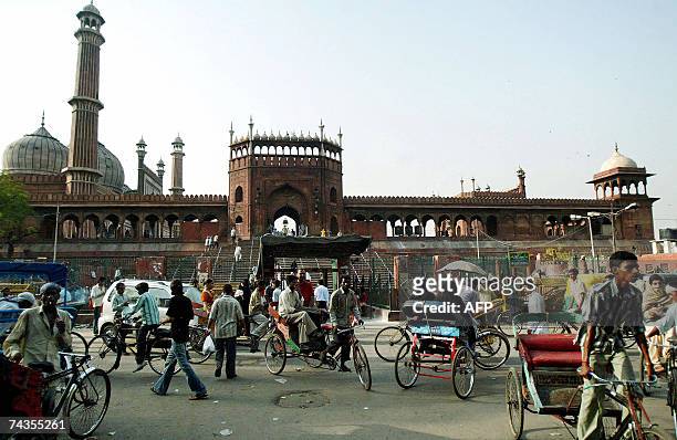 Indian commuters and pedestrians travel past the southern gate of The Jama Masjid in New Delhi, 17 May 2007. The principal mosque of Old Delhi in...