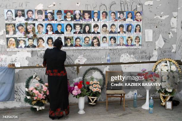 Beslan, RUSSIAN FEDERATION: A woman stands near chidren's pictures in the destroyed school sport hall in Beslan, 30 May 2007. Beslan holds a mourning...