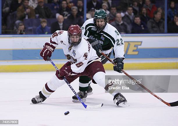 Brett Motherwell of the Boston College Eagles skates to the puck against Nick Sucharski of the Michigan State Spartans during the Frozen Four...