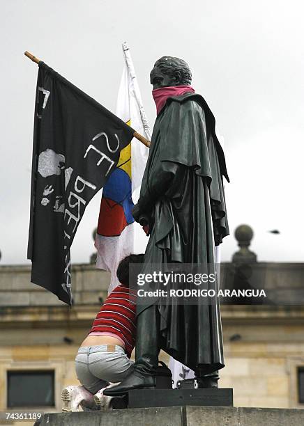 Una estudiante coloca banderas junto a la estatua del Libertador Simon Bolivar el 30 mayo de 2007 en Bogota durante una jornada de marchas en contra...