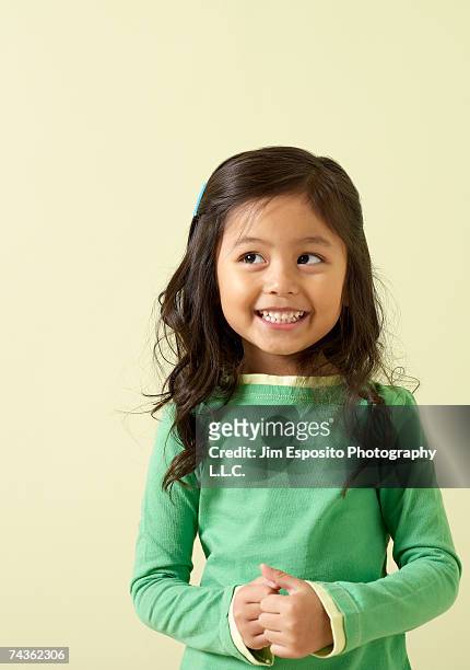 girl (4-5) smiling, looking away - brown hair stock-fotos und bilder