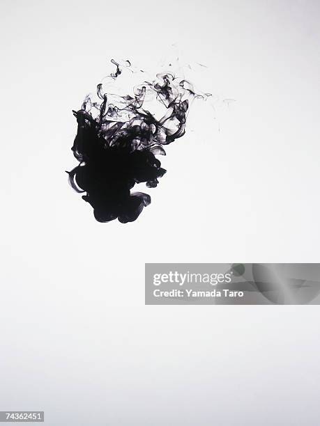 black ink dissolving in water - ink photos et images de collection