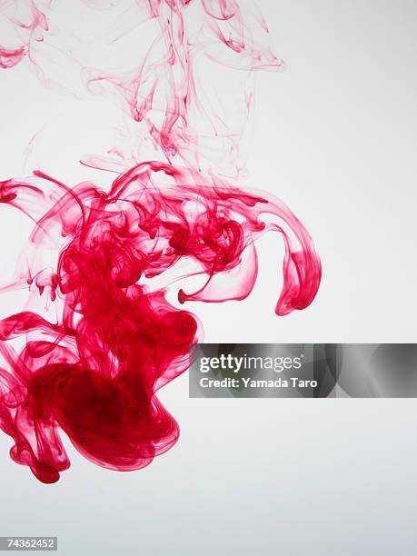 pink ink dissolving in water - dissolving stockfoto's en -beelden