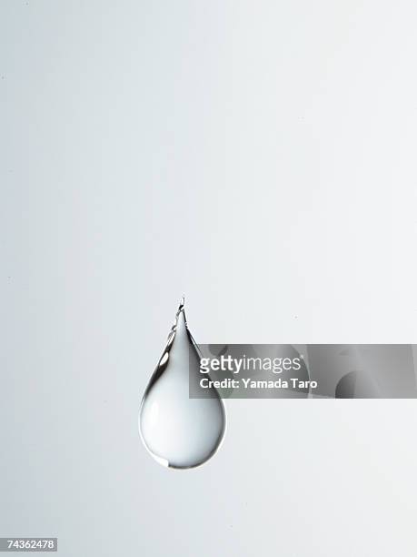 tear shaped water drop suspended in air, close-up - wasser stock-fotos und bilder