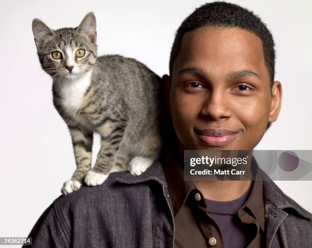 young man with cat, smiling, portrait, studio shot - cat studio shot stock pictures, royalty-free photos & images