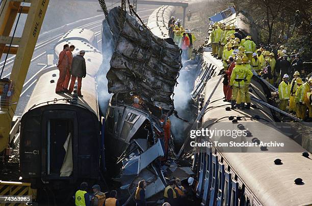 Firefighters and policemen work to free the dead and rescue the injured from the derailed carriages after a rail crash near Clapham Junction in...