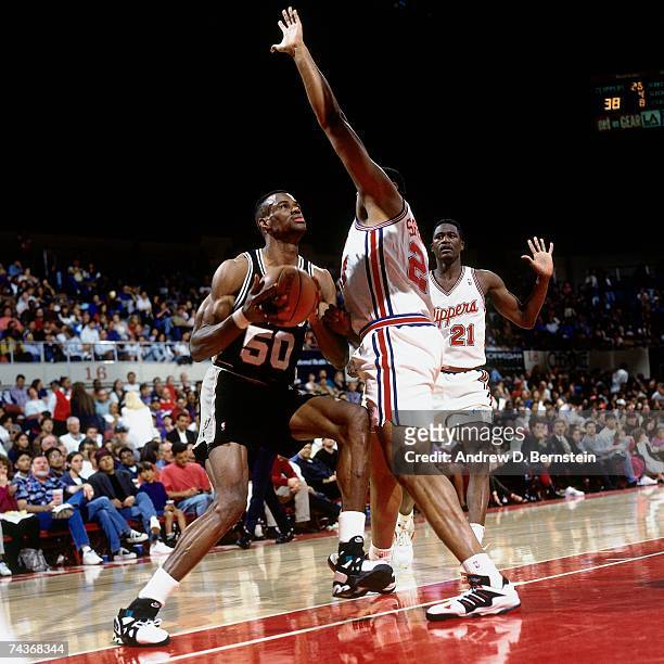 David Robinson of the San Antonio Spurs makes a move to the basket against Elmore Spencer and Dominique Wilkins of the Los Angeles Clippers on April...