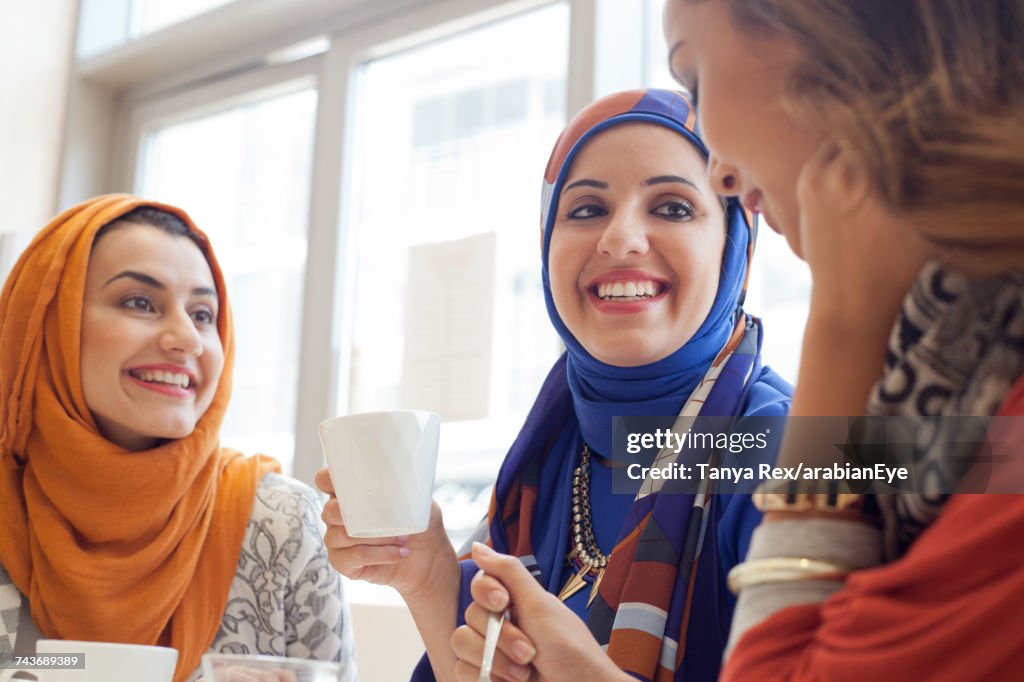 Young women chatting at café. 