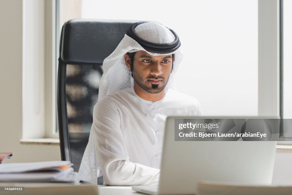 Emirati businessman working at office.