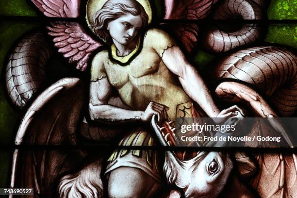 notre-dame of geneva basilica. stained glass window. angel fighting satan as a dragon. switzerland. - dämon-fiktionale-figur stock-fotos und bilder