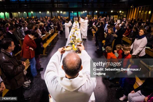 eucharist celebration in a paris catholic church. france. - maundy thursday stock pictures, royalty-free photos & images