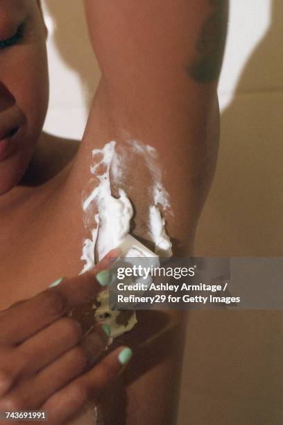 young woman shaving her armpits - 67percentcollection stockfoto's en -beelden