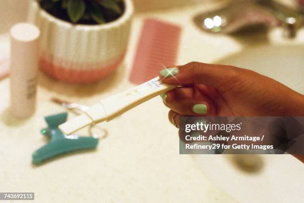 young woman looking at pregnancy test  - 67percentcollection stockfoto's en -beelden