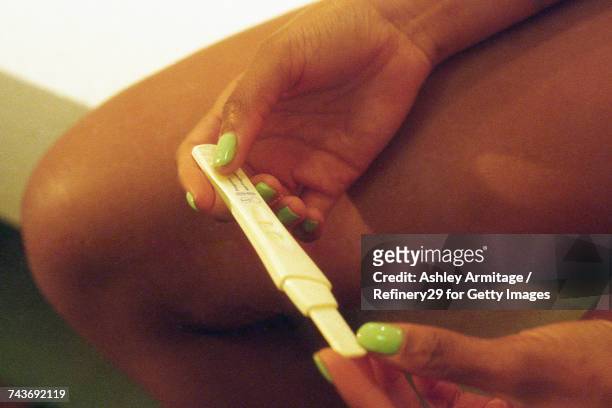 young woman looking at pregnancy test  - 67percentcollection stockfoto's en -beelden