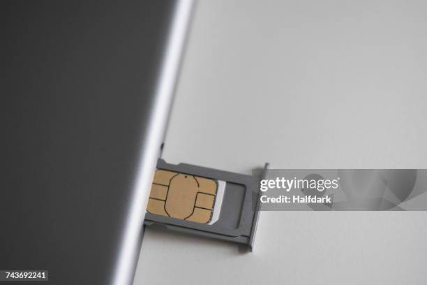 close-up of sim card and mobile phone on white table - sim card stockfoto's en -beelden