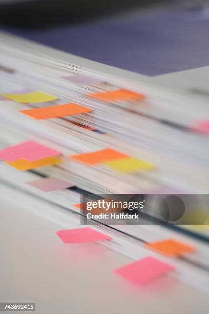 high angle view of stack of books with colorful bookmarks on table - bookmark stock pictures, royalty-free photos & images