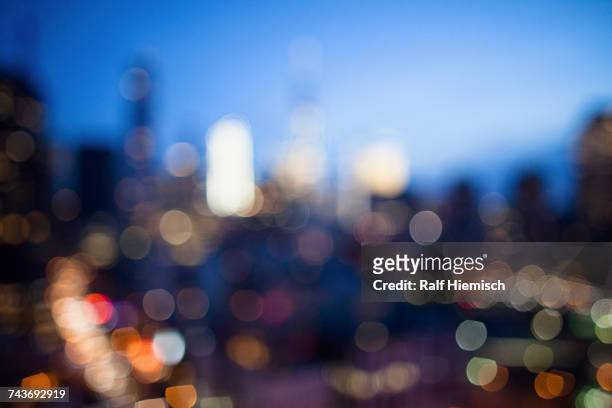 defocused image of illuminated cityscape at dusk - street light stock pictures, royalty-free photos & images
