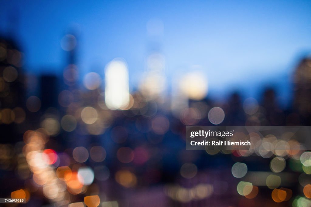Defocused image of illuminated cityscape at dusk