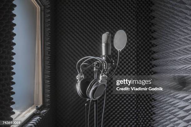 close-up of headphones on microphone stand in soundproof recording studio - equipo de grabación de sonido fotografías e imágenes de stock