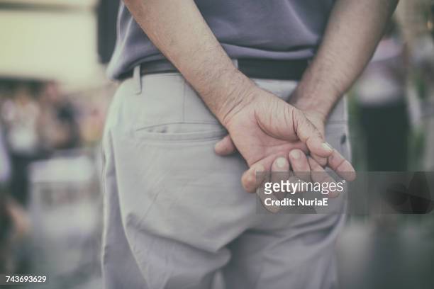 man holding his hands behind his back - mãos atrás das costas - fotografias e filmes do acervo