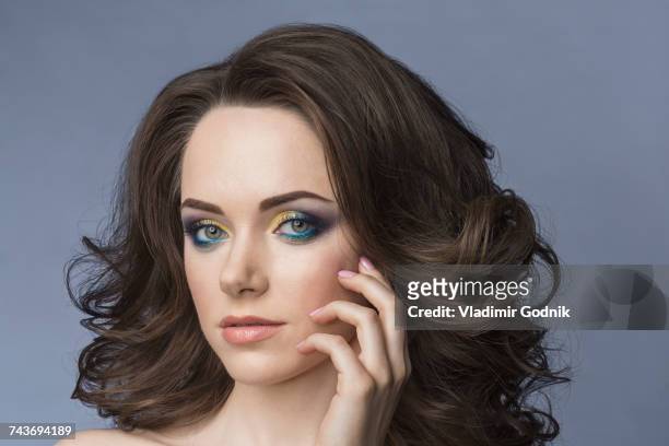 close-up portrait of young woman with eye make-up against gray background - eyeshadow foto e immagini stock