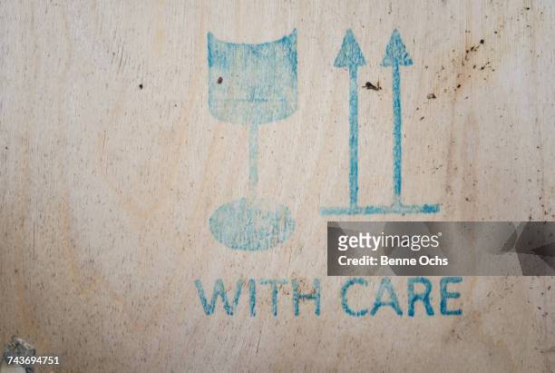 close-up of with care sign on wooden crate - wooden sign post stockfoto's en -beelden