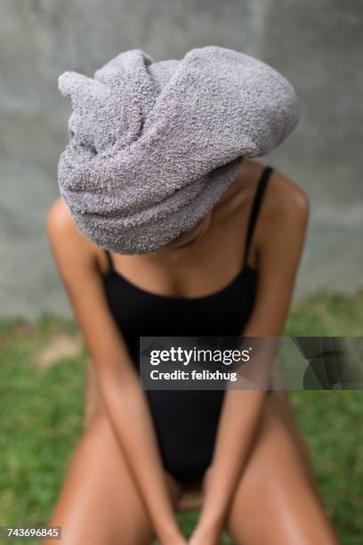 young woman sitting on a chair with a towel on her head - bodystocking stock pictures, royalty-free photos & images