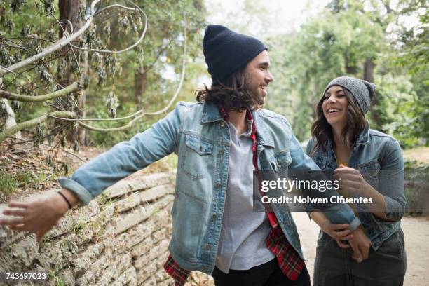 playful couple at park - versierd jak stockfoto's en -beelden