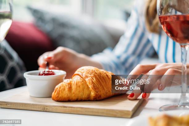 woman eating a croissant with jam - croissant jam stock pictures, royalty-free photos & images