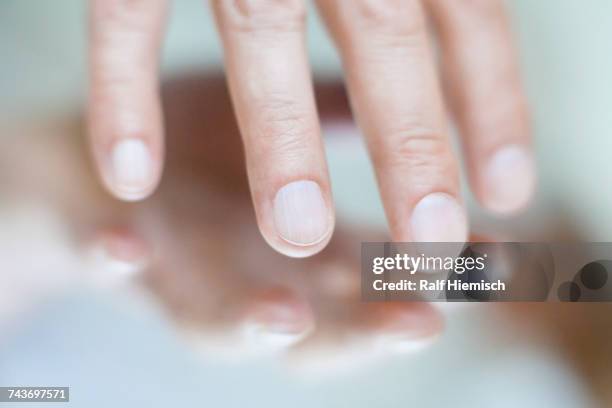 cropped image of hand touching mirror surface - toccare foto e immagini stock