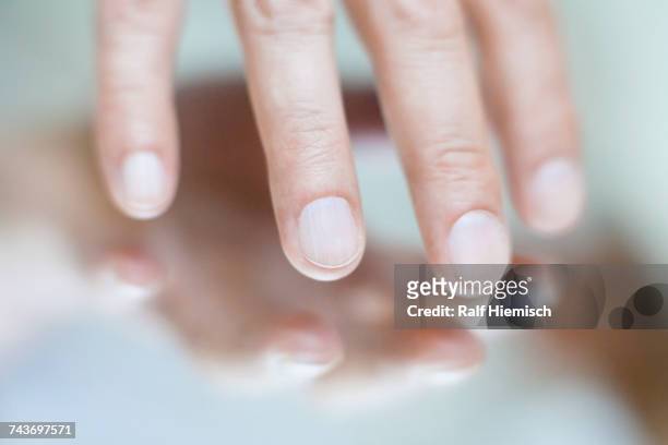 cropped image of hand touching mirror surface - touching stock pictures, royalty-free photos & images