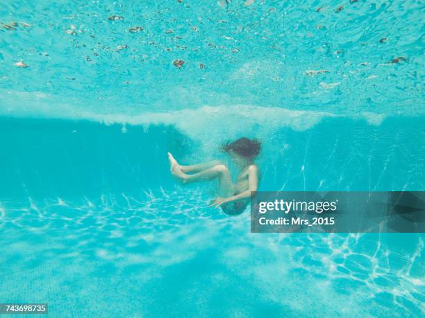 underwater view of a boy jumping into a swimming pool - cannonball diving stock pictures, royalty-free photos & images