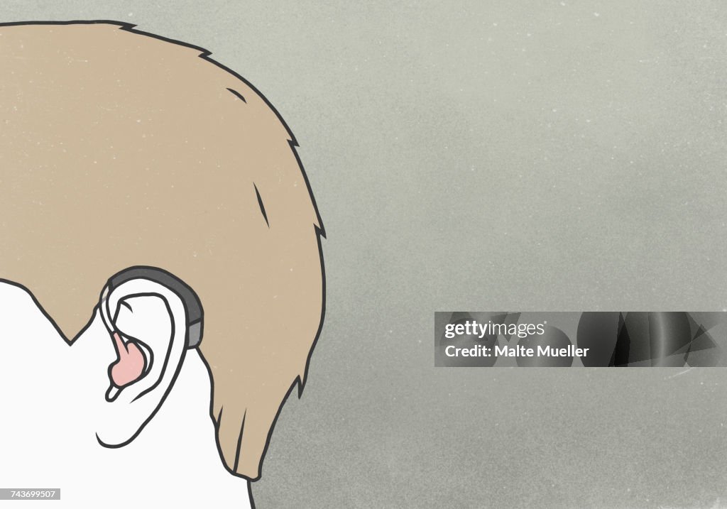 Cropped image of man wearing hearing aid against gray background