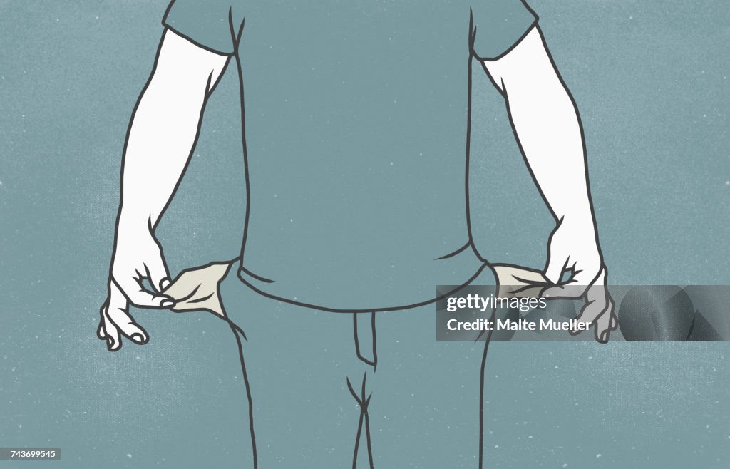 Midsection of man with showing empty pockets against gray background