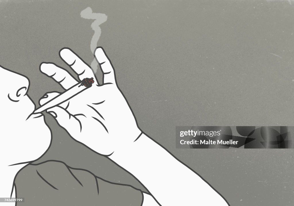 Cropped image of man smoking marijuana against gray background