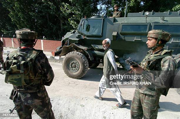 Indian paramilitary soldiers stand at the site after a blast damaged an Indian Army bus in Srinagar, 01 June 2007. An explosion in the Rajbagh area...