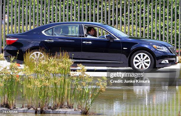 Japanese Prime Minister Shinzo Abe drives one of Toyota Motor Corporation's hybrid cars, the Lexus LS600hL, at the Prime Minister's official...