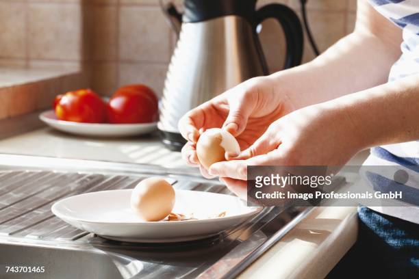 hard-boiled eggs being shelled - hard boiled eggs stock-fotos und bilder