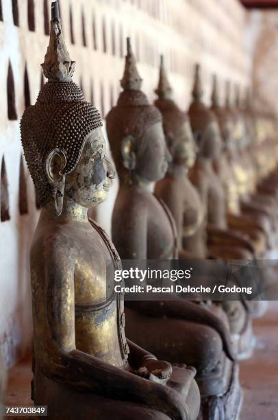 wat sisaket (si saket) buddhist temple.  old buddha statues in the cloister or gallery surrounding the sim.  laos. - wat si saket imagens e fotografias de stock